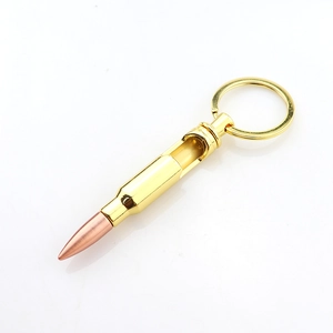 Golden bullet-shaped bottle opener keychain with a copper tip on a clean white background