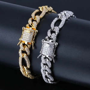 Close-up of gold and silver cuban link bracelets with sparkling cubic zirconia inlay