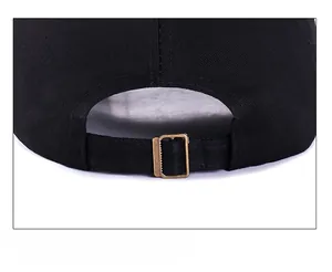 Gros plan sur la casquette en coton noir avec boucle de réglage en métal bronze antique
