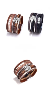 Detail of multi-layer leather bracelet with tree of life charm and magnetic clasp