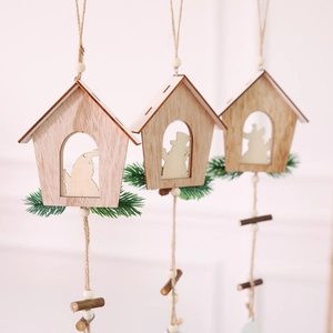 Detail of wooden Christmas house ornaments with twine, wood beads, and pine needle accents