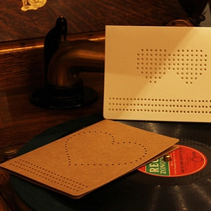 DIY kraft paper heart embroidery card on vintage vinyl player with warm lighting