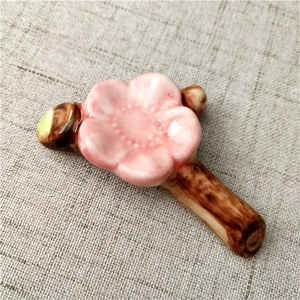 Detailed view of ceramic cherry blossom chopstick rest on natural linen background