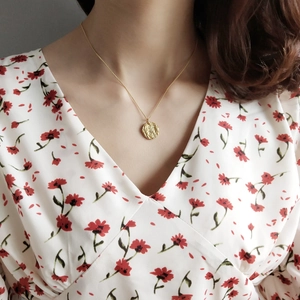 Minimalist 925 sterling silver necklace with a gold coin pendant worn by a model