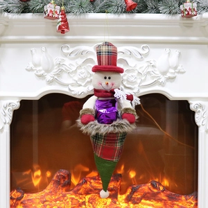 Christmas snowman ornament with plaid hat and gift box hanging on a festive white fireplace