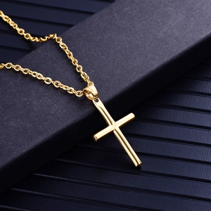 Detail of a polished golden stainless steel cross pendant on an O-chain necklace