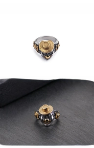 Macro detail of punk style steel clown ring with golden hat and retro finish