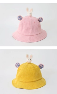 Detail of pink and yellow corduroy sun hats with cute plush bunny decor for kids