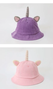 Detailed corduroy texture of unicorn bucket hats in purple and pink for children