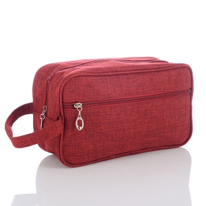 Detail view of burgundy men's toiletry bag with linen texture and silver zipper handles