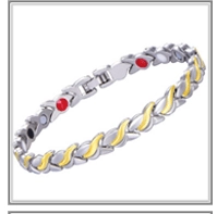 Macro view of gold and silver steel therapy bracelet with magnetic stones and fold-over clasp