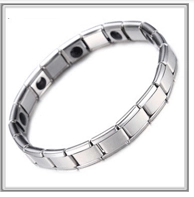 Close-up of gold-plated copper bracelet links with black magnetic therapy inserts