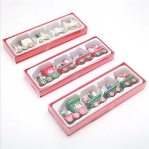 Three sets of festive wooden Christmas train decorations in red gift packaging boxes