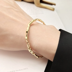 Minimalist S925 silver irregular wave textured gold bangle worn on a model's wrist