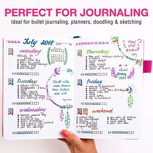 POV shot of a dotted grid notebook for journaling with colorful marker hand-drawn artwork