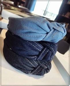 Close-up of denim knotted headbands with contrast orange stitching in three blue washes