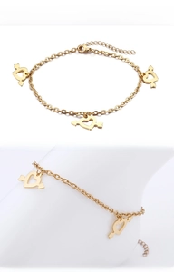 Detail of a gold heart-and-arrow charm anklet with adjustable chain and lobster clasp