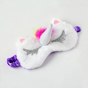 Detail of plush unicorn eye mask with embroidered eyelashes and purple elastic band