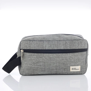 Grey fabric toiletry bag for men with black zipper and side handle on white background