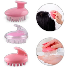 Detail view of pink V-shaped scalp massage brush showing bristles and foaming action