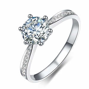 Primo piano di un anello in argento con zircone tondo a sei griffe e pietre laterali