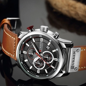 Detailed macro of CURREN chronograph watch with silver case and brown leather strap