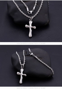 Macro shot of silver fluid-style stainless steel cross pendant and rope chain details