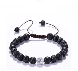 Macro shot of 8mm lava rock beads and single white turquoise on adjustable cord