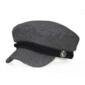 Detailed macro of grey wool patchwork baker boy hat with black braided strap and silver button