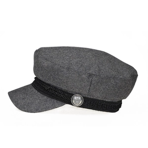 Detailed shot of dark grey wool baker boy hat featuring a braided band and crown button