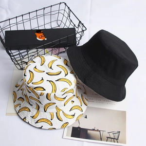 Detail of reversible canvas bucket hats showing black side and yellow banana print pattern