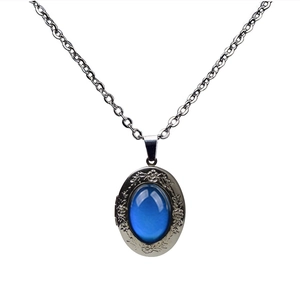 Vintage oval pendant necklace with blue gemstone and floral engraving on silver chain