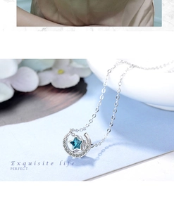 Nahaufnahme der silbernen Mondsichel-Halskette mit blauem Sternkristall und Diamanten