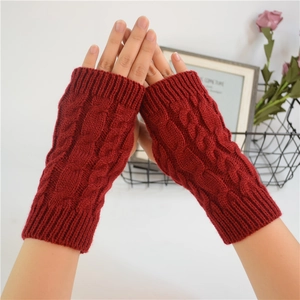 Close-up of deep red cable knit fingerless gloves with warm winter wool texture