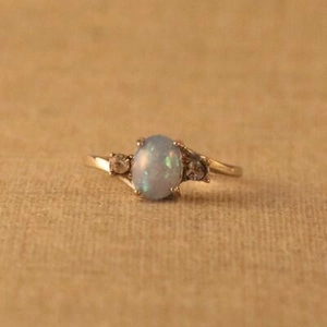 Eleganter Goldring mit ovalem Opal in Blaugrün und seitlichen Diamanten für Damen