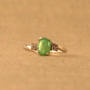 Eleganter Silberring mit ovalem grünen Opal und zwei Seitendiamanten auf neutralem Grund