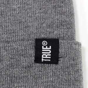 Grey knit beanie featuring a TRUE brand woven label and cozy ribbed texture for winter