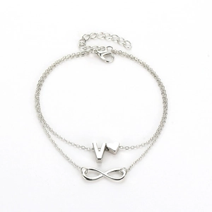 Detailed macro view of silver double-layer anklet with infinity, heart, and V pendants