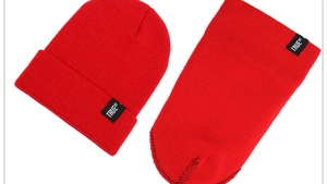 Detail shot of the red knitted beanie and neck warmer set with True brand logo