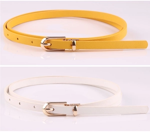 Detail of yellow and white slim PU leather belts with gold pin buckles and fine texture