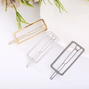 Close-up of geometric hollow rectangular hair clips in gold, silver and gunmetal finish