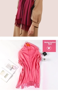 Detailed view of soft winter cashmere scarf with delicate tassels in watermelon red