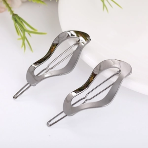 Close-up of a pair of minimalist wavy gunmetal hairpins on a clean white surface