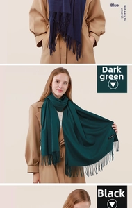 Detailed close-up of premium cashmere scarf fringe and fabric texture in dark green and black
