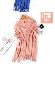 Detail of light pink cashmere-feel scarf with long tassels and stylish accessories