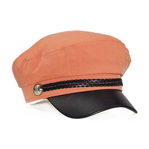 Detail view of orange newsboy hat with black leather visor and silver button accents