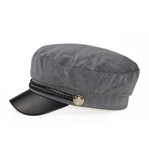 Detail of grey fabric navy cap with black faux leather brim and woven cord decoration