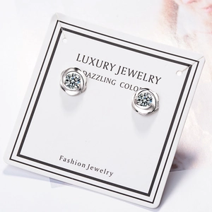 Silver rose flower stud earrings with sparkling zircon crystals on white jewelry card