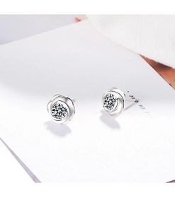 Close-up of rose flower earrings with silver petals and a sparkling zircon center