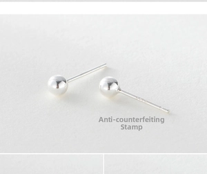 Macro shot of minimalist S925 sterling silver ball stud earrings with clear hallmark